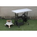 A GARDEN TABLE, the oblong veined white marble slab on a Singer sewing machine cast iron stand,