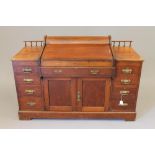 A LATE VICTORIAN WALNUT "BRADFORD DESK LIBRARY VERSION" by Christopher Pratt & Sons, of usual