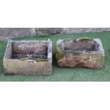 A SMALL SANDSTONE TROUGH of rough hewn oblong form, 18 1/2" x 12 1/2" x 8", together with another