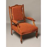 AN EDWARDIAN ROSEWOOD FRAMED ARMCHAIR with stringing and upholstered in a rust coloured weave, the