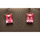 A PAIR OF PINK TOPAZ EAR STUDS, the Princess cut stones claw set in white metal, butterflies stamped