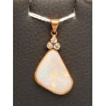 A MODERN OPAL AND DIAMOND PENDANT, the asymmetrical polished Australian opal collet set below