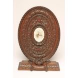 A VICTORIAN OAK FREE-STANDING OVAL FRAME, possibly French, centred by an oval miniature aperture