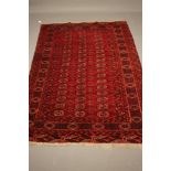 A TEKKE TURKOMAN RUG, the red field with repeating linked gul pattern in ivory, navy blue and