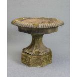 A LARGE VICTORIAN SANDSTONE URN of circular faceted form, the shallow bowl with broad fluted rim, on