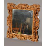 A CARVED AND PAINTED PINE WALL MIRROR, 19th century, of oblong form, with later mirror plate,