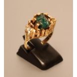 A MODERNIST COCKTAIL RING centred by an uncut dioptase claw set to an asymmetric panel with a