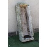 A LARGE GRANITE TROUGH of rough hewn narrow oblong form with mildly tapering sides, 19" x 53" x