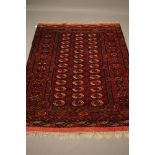 A TEKKE TURKOMAN RUG, the red field with repeating linked gul pattern in ivory, navy blue and