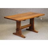 AN ADZED OAK REFECTORY TABLE by Colin Almack, the rounded oblong top raised on two waisted