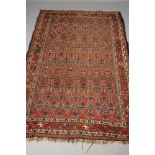 A PERSIAN TRIBAL RUG, the navy blue field with repeating red guls, each with a tree in blue,