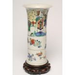 A CHINESE PORCELAIN BEAKER VASE painted in famille verte enamels with figures over fruiting peach