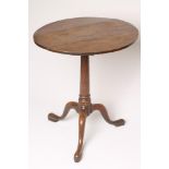 A GEORGIAN OAK TRIPOD TABLE, c.1800, the circular tip up top on turned gun barrel stem, the base