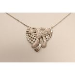 AN ART DECO DIAMOND NECKLACE, the open asymmetric stylised ribbon bow with open back collet, pave