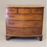 A GEORGIAN MAHOGANY CHEST, early 19th century, of bowed form with stringing, moulded edged top