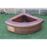 A SALTGLAZE STONEWARE TROUGH of quadrant form with moulded rim, and stamped Incham & Sons,