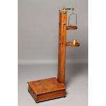 AN OAK STANDING HEIGHT AND WEIGHT JOCKEY SCALES, c.1900, with brass mounts and weights, the square