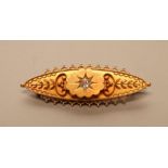 A LATE VICTORIAN 15CT GOLD BROOCH, the eliptical panel centred by an old brilliant cut diamond