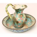 A CANTON ENAMEL TOILET JUG AND BASIN, the baluster jug painted in colours with a panel of two