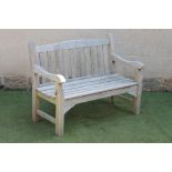 A TEAK BENCH, modern, with slatted arch back, slatted seat, shaped arm supports and square section