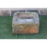 A SANDSTONE TROUGH of rough hewn irregular square form, 23" (approx.) x 21 1/2" x 12 1/2" (Est. plus