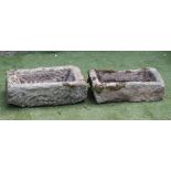 A SMALL SANDSTONE TROUGH of rough hewn oblong form, 25" x 14" x 8 1/2", together with another