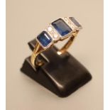 AN ART DECO STYLE SAPPHIRE AND DIAMOND HALF HOOP RING, the three oblong facet cut collet set