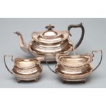 A THREE PIECE SILVER TEA SERVICE, maker Barker Bros., Chester 1914, of rounded oblong baluster form,