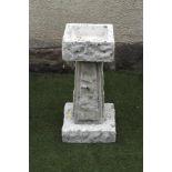 A COMPOSITION STONE BIRD BATH of rusticated square form raised on tapering panelled stem, 10 1/2"