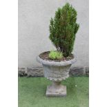 A LARGE COMPOSITION STONE URN, the tapering bowl with a trailing fruiting vine and moulded rim, leaf