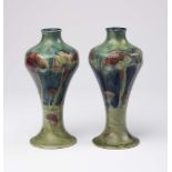 A PAIR OF MOORCROFT POTTERY VASES, early 20th century, of slender inverted baluster form,