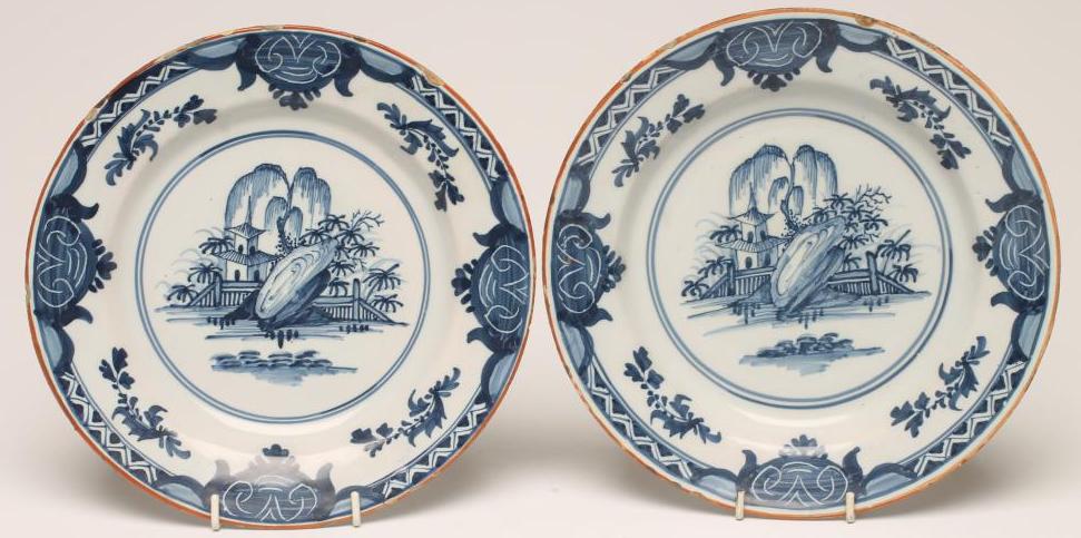 A PAIR OF DELFT PLATES, late 18th century, painted in blue with a pagoda, fence and rocks within a