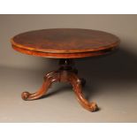 A VICTORIAN ROSEWOOD CENTRE TABLE of circular form, the moulded edged tip up top on lotus carved