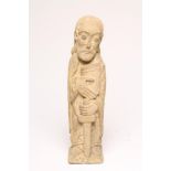 AN ARTS AND CRAFTS STONE FIGURE of St Paul The Apostle, carved standing holding a book and a