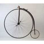 A PENNY FARTHING BICYCLE with stamped metal seat, down turned handle bars and turned horn grips,