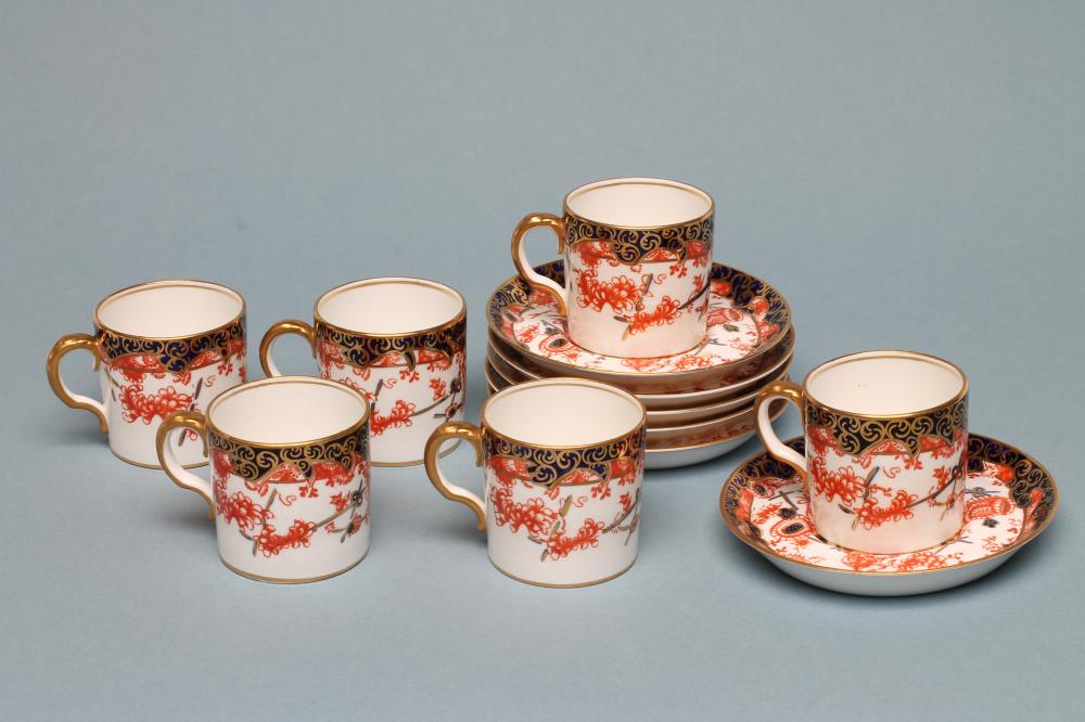 A SET OF SIX ROYAL CROWN DERBY CHINA COFFEE CANS AND SAUCERS, 1912, printed and over painted in