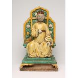 A CHINESE EARTHENWARE FIGURE modelled as a dignitary seated on a flower moulded throne on a