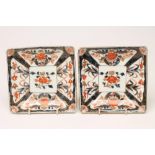 A PAIR OF IMARI PORCELAIN SQUARE DISHES painted in typical palette with panels of iris and potted