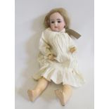 A Kammer & Reinhardt bisque head doll with brown glass sleeping eyes, open mouth and teeth,