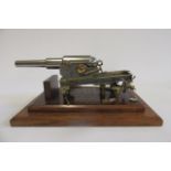A model canon in steel with brass fittings comprising 8 1/2" cannon on detailed wheeled base,