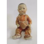 An Armand Marseille bisque head Oriental boy doll with brown glass sleeping eyes, closed mouth,