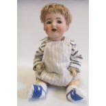 A Kammer & Reinhardt bisque head character doll with blue glass flirty eyes, open mouth and teeth,