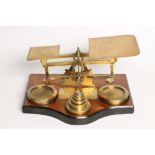 A SET OF BRASS POSTAL SCALES, c.1900, with 1oz-4lb brass circular weights, on serpentine fronted