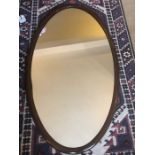 Oval mahogany wall hanging mirror with string inlay.