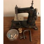 Miniature sewing machine + bobbins.