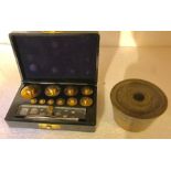 A set of English brass cup weights and a bakelite box of weights.