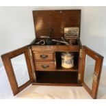 Good quality oak smokers cabinet with ceramic tobacco jar and various pipes.