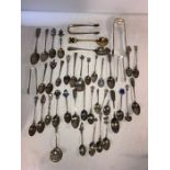 A vast quantity of silver and white metal spoons and tongs etc.