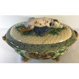 Minton majolica game pie dish with recumbent dog to lid. (lid stapled) 32cm across