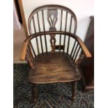 A 19thC low backed Windsor armchair with crinoline stretchers.